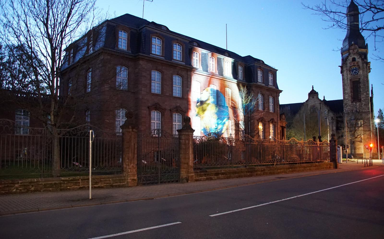 Videoprojektion auf die Fassade des Landratsamts: "Wir haben es in der Hand" - Zwei Hände halten die Welt