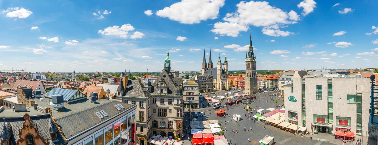Panoramablick über die Innenstadt von Halle mit Marktständen, Kirchtürmen und weiteren Gebäuden