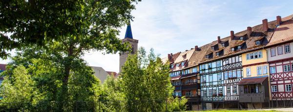 Bunte Fachwerkhäuser grenzen an einen Park.