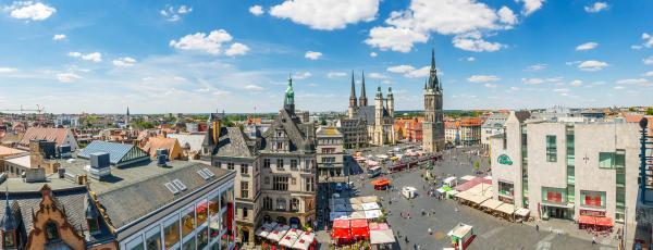 Panoramablick über die Innenstadt von Halle mit Marktständen, Kirchtürmen und weiteren Gebäuden